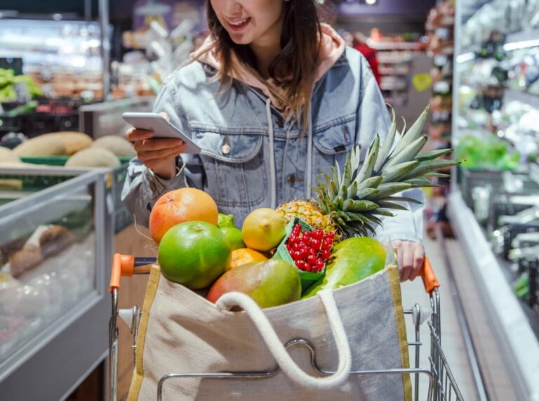 mujer-en-super-mercado-con-frutas-usando-el-telefono