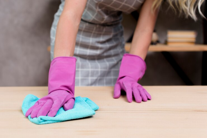 mujer-limpiando-madera-con-guantes-rosados