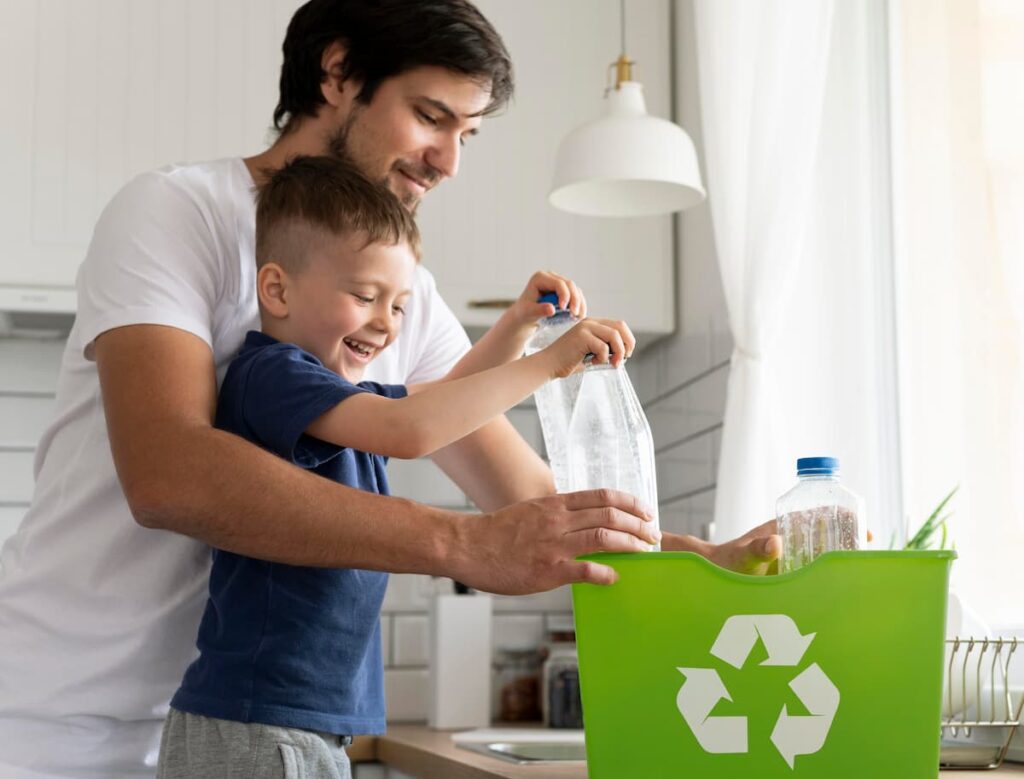 hombre joven con barba reciclando productos biodegradables con su hijo